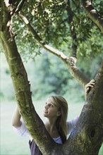 Smiling woman behind tree