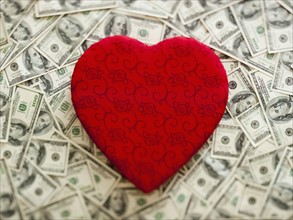 Symbolic red heart wtih US dollars as background