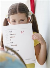Child holding up grades