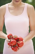 Woman holding tomatoes.