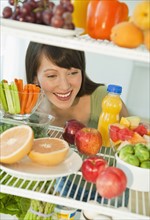 Woman looking in fridge.