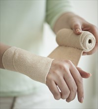 Wrapping hand in tensor bandage.