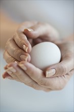 Hands holding egg.