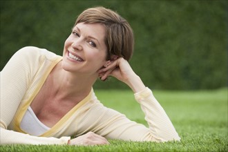 Woman lying on grass smiling.