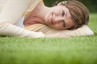 Contented woman lying on grass.
