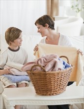 Mother and child folding laundry.