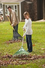 Man and girl raking leaves.