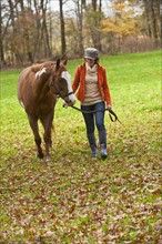Woman walking with horse.