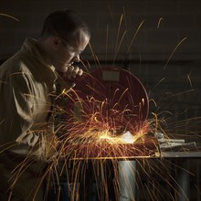 Steel grinder working in metal shop