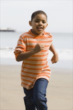 Young boy running on beach