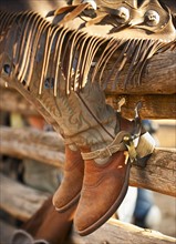 Cowboy boots on fence.