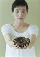 Woman holding nest.