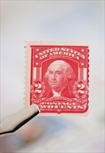Tweezers holding stamp.