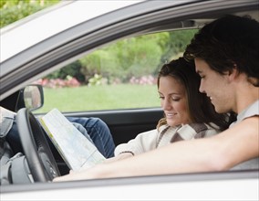 Couple in car looking at map