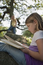 Girl reading book in tree