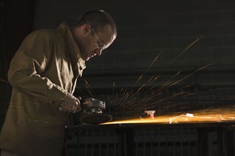 Steel grinder working in metal shop