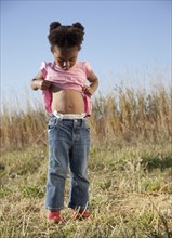 Young girl looking at her belly button