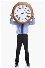 Man holding clock in front of face