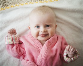 Smiling baby girl in pink robe