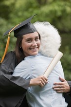 Graduate hugs elderly woman