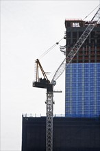 Crane beside high-rise building