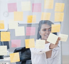 Woman looking at post-it notes