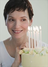 Woman looking at candles on cake.