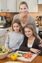 Mother and daughters making salad.