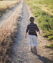 Young boy walking on rural path