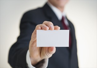 Businessman holding white card.