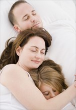 Family sleeping together. Photographer: Jamie Grill