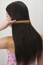 Woman combing her hair. Photographer: Daniel Grill