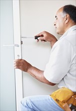 Man fixing door. Photographer: momentimages