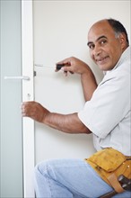 Man fixing door. Photographer: momentimages