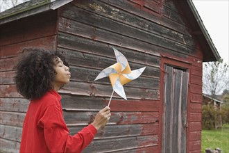 Girl blowing toy windmill. Photographer: Pauline St.Denis
