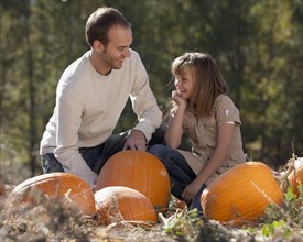 Father and daughter in pumpkin patch. Photographer: Mike Kemp