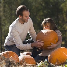 Father and daughter in pumpkin patch. Photographer: Mike Kemp