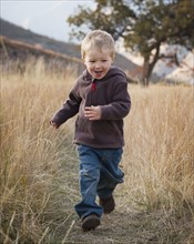 Boy running in meadow. Photographer: Mike Kemp