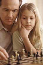 Father and daughter playing chess. Photographer: Rob Lewine