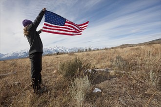 Hiker holding American flag. Photographer: Dan Bannister