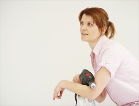 Woman holding a drill. Photographer: momentimages