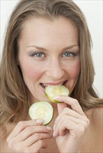 Woman eating cucumber.
