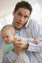 Businessman holding baby.