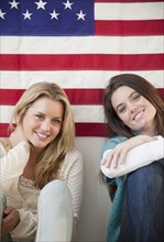 Friends sitting in front of American flag. Photographer: Jamie Grill