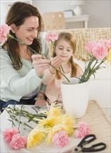 Mother and daughter making flower arrangement. Photographer: Jamie Grill