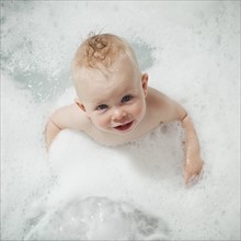 Baby having a bubble bath. Photographer: Mike Kemp