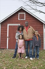 Family standing in front of barn. Photographer: Pauline St.Denis