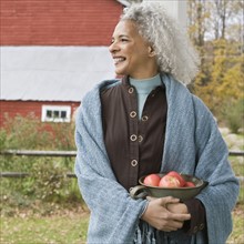 Woman holding bowl of apples. Photographer: Pauline St.Denis