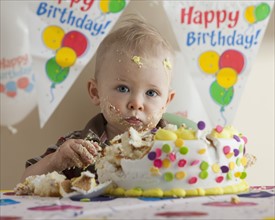 Baby eating birthday cake. Photographer: Mike Kemp