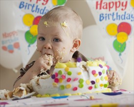 Baby eating birthday cake. Photographer: Mike Kemp